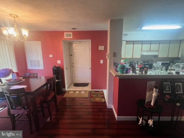 dining area featuring hardwood / wood-style flooring and an inviting chandelier