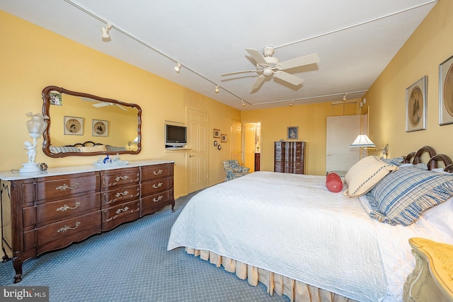 bedroom with carpet floors, rail lighting, and a ceiling fan