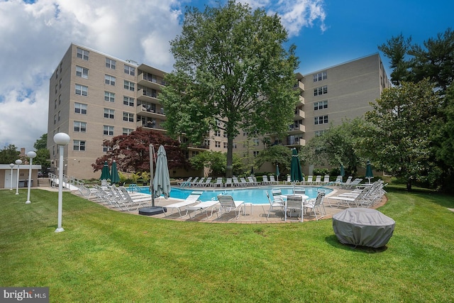 pool with a patio and a yard