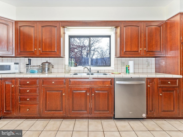 kitchen featuring dishwasher, light tile patterned floors, backsplash, and sink