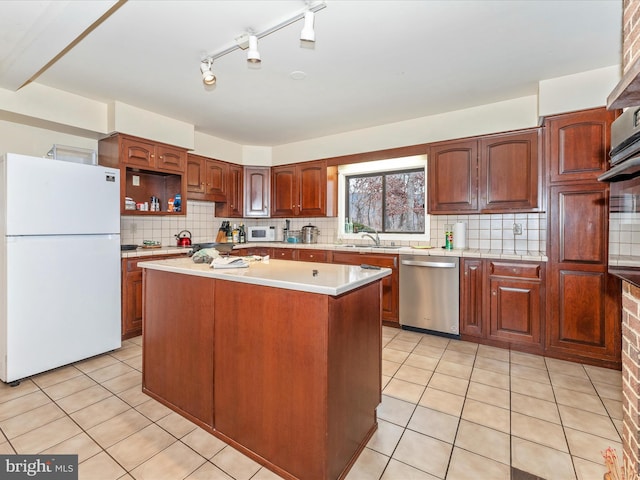 kitchen featuring light tile patterned floors, white appliances, a kitchen island, and backsplash