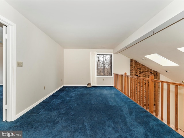 bonus room with dark carpet and lofted ceiling with skylight