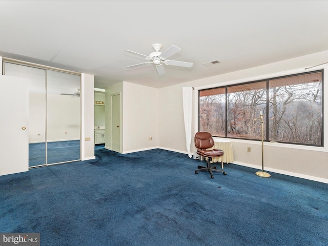 unfurnished room featuring ceiling fan and dark carpet