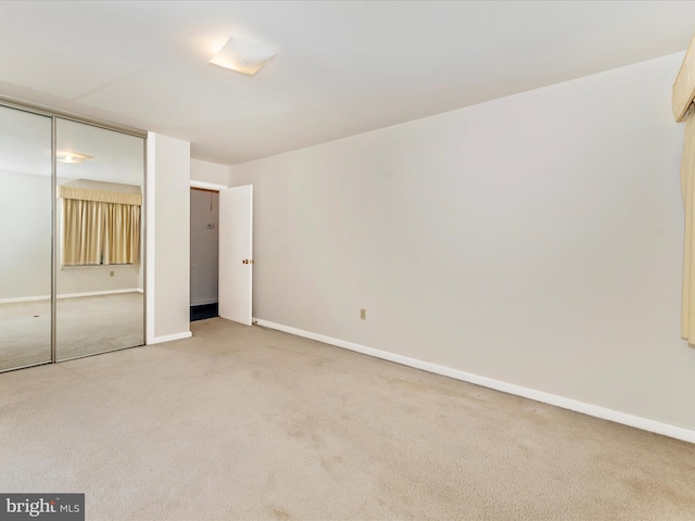 unfurnished bedroom with light carpet and a closet