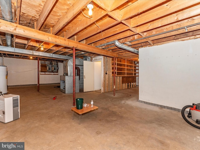 basement featuring electric panel and water heater