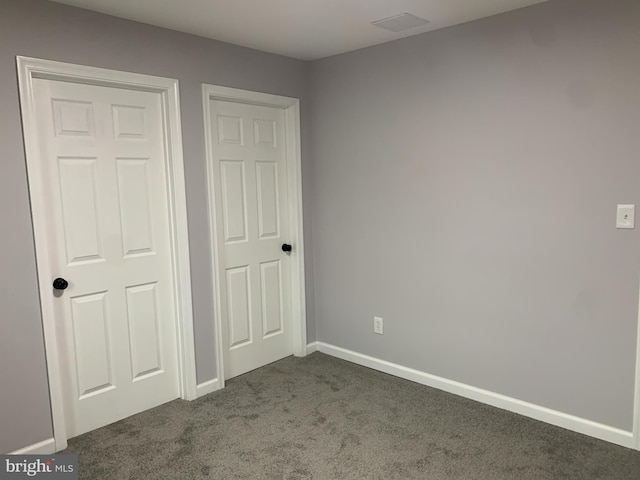 unfurnished bedroom with dark colored carpet