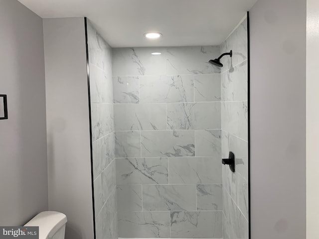 bathroom with toilet and tiled shower