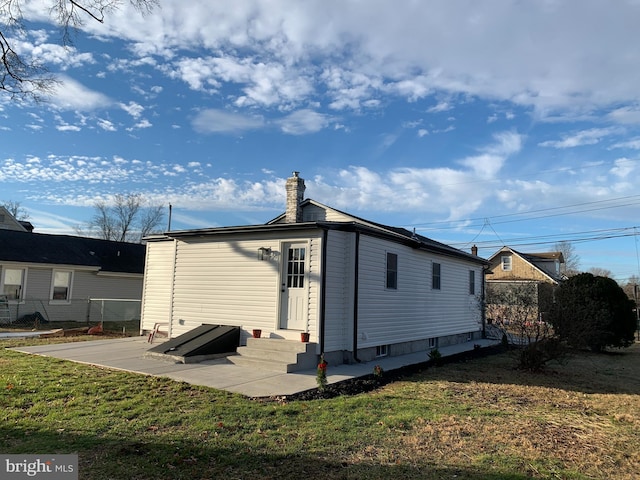 back of house with a lawn and a patio area