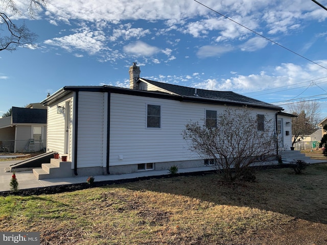 view of side of home with a yard