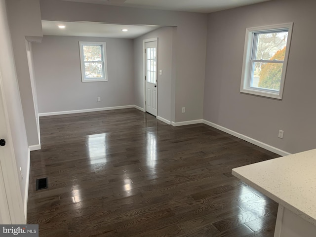 spare room featuring dark hardwood / wood-style flooring and plenty of natural light