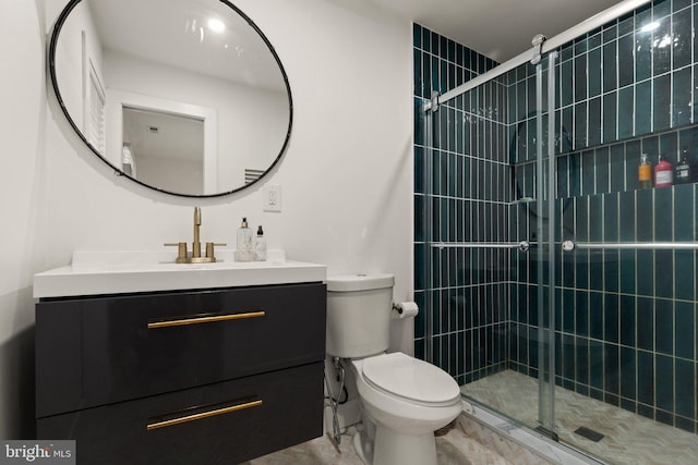 bathroom featuring vanity, a shower with shower door, and toilet