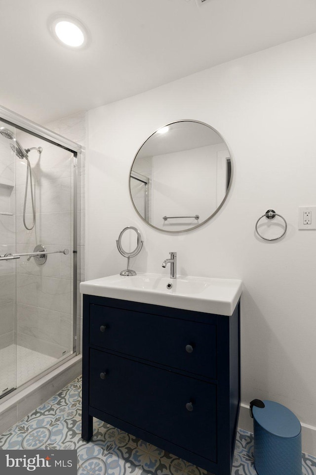 bathroom with tile patterned flooring, vanity, and a shower with shower door