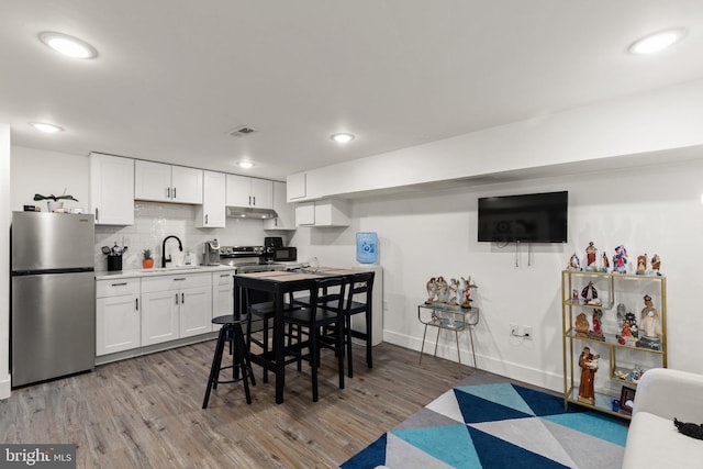 kitchen featuring hardwood / wood-style flooring, sink, white cabinets, and appliances with stainless steel finishes