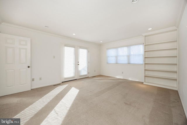 spare room with ornamental molding and light carpet