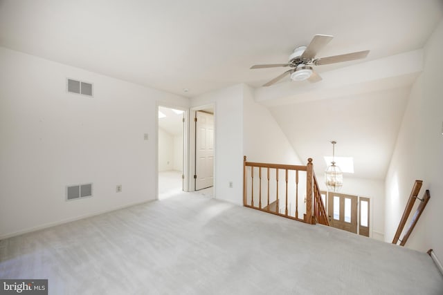 carpeted empty room featuring ceiling fan with notable chandelier