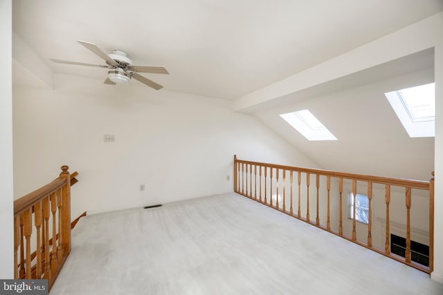 additional living space with lofted ceiling with beams, light colored carpet, and ceiling fan