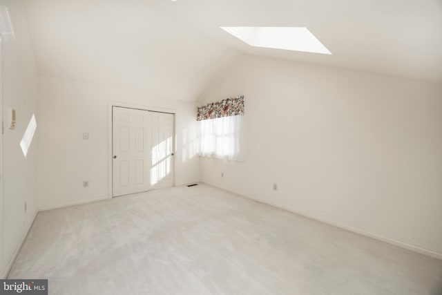 bonus room with light colored carpet and lofted ceiling with skylight