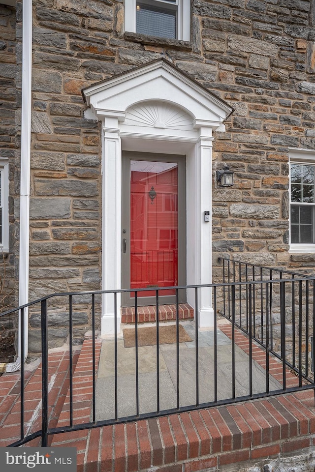 doorway to property featuring stone siding