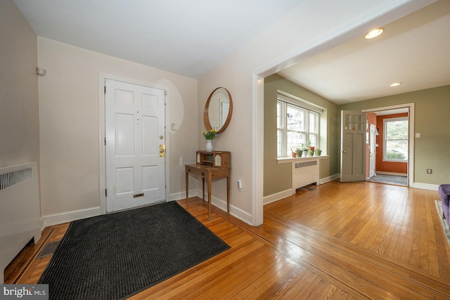 entryway featuring baseboards, radiator heating unit, and hardwood / wood-style flooring