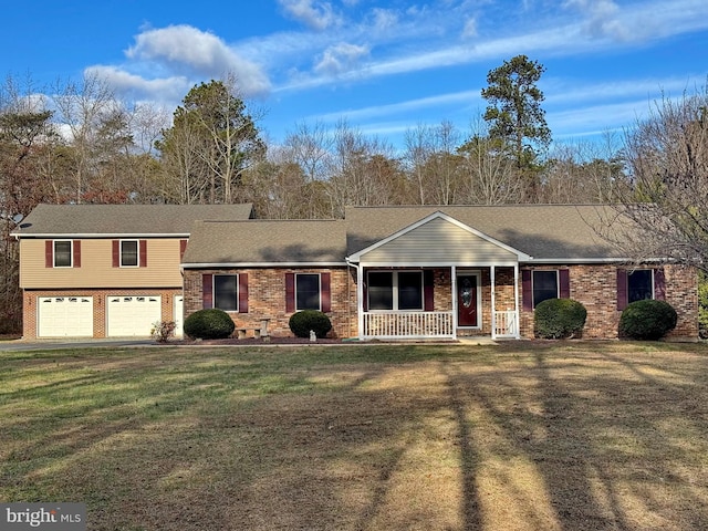 view of front of house with covered porch, a garage, and a front lawn