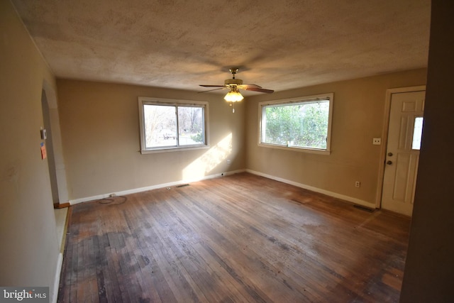 unfurnished room featuring dark hardwood / wood-style floors, ceiling fan, and a textured ceiling