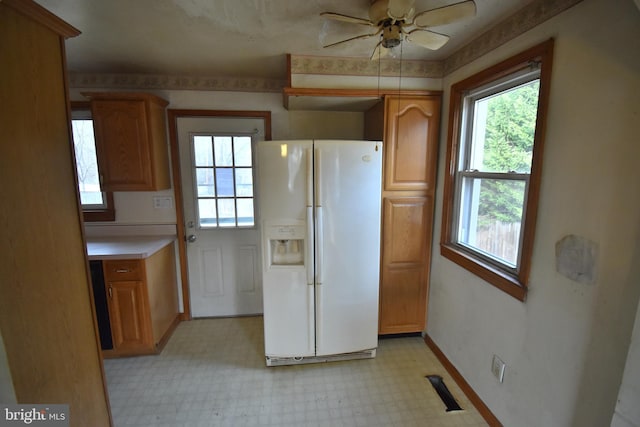 kitchen featuring white refrigerator with ice dispenser and ceiling fan