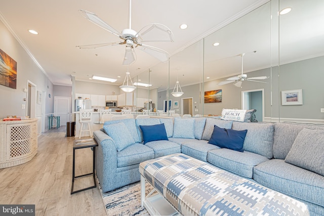 living room with ceiling fan, crown molding, and light hardwood / wood-style flooring