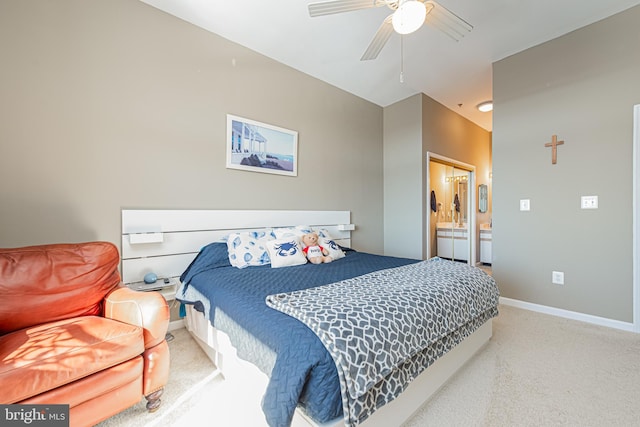 bedroom featuring light carpet, ensuite bathroom, and ceiling fan