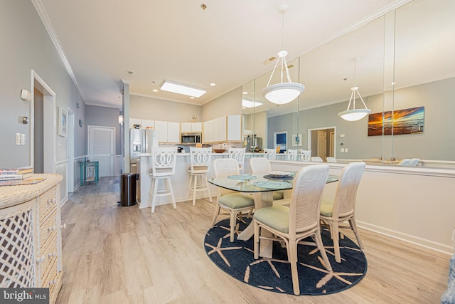 dining area featuring crown molding and light wood-type flooring