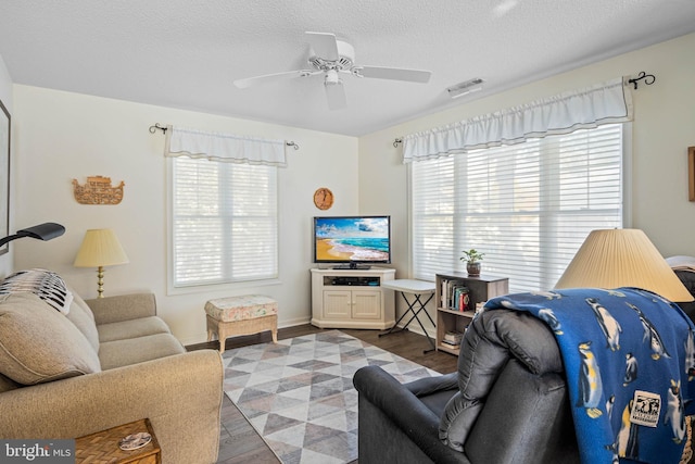 living room with wood-type flooring, a textured ceiling, and ceiling fan