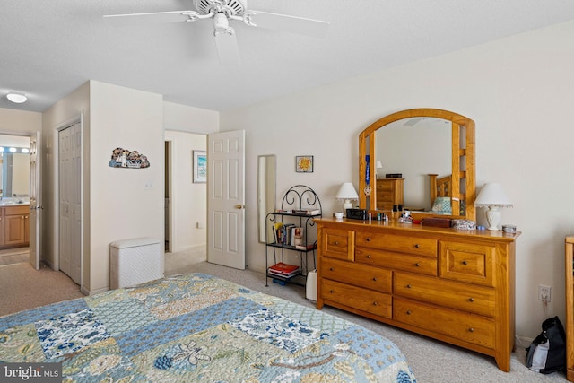 bedroom featuring ensuite bath, ceiling fan, light colored carpet, a textured ceiling, and a closet