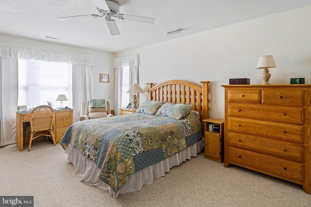 carpeted bedroom with ceiling fan and a textured ceiling