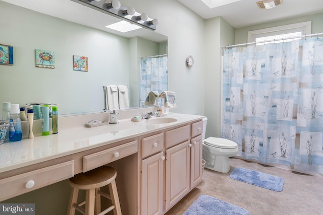 bathroom with vanity, a skylight, toilet, and walk in shower