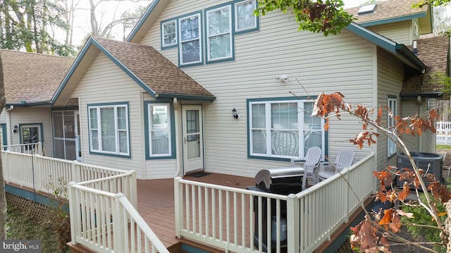 rear view of property with a deck and central AC unit