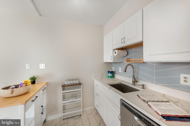 kitchen featuring tasteful backsplash, white cabinetry, sink, and dishwasher