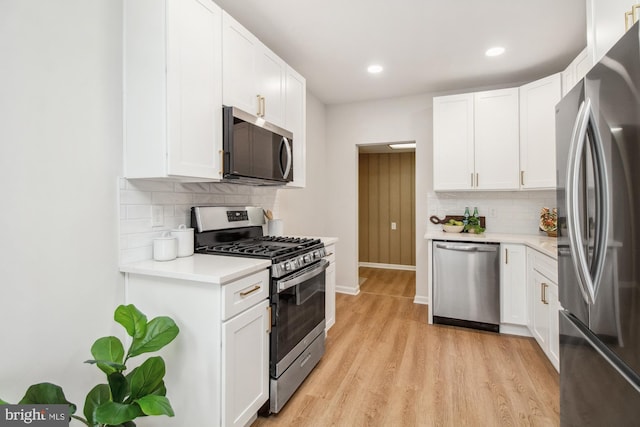 kitchen featuring white cabinets, stainless steel appliances, and tasteful backsplash