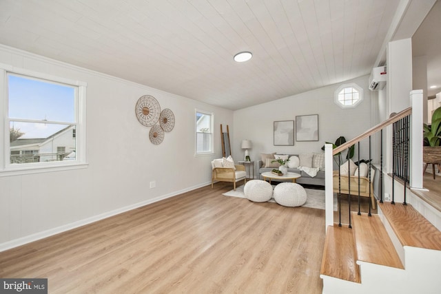 sitting room featuring an AC wall unit, light hardwood / wood-style flooring, wooden ceiling, and vaulted ceiling