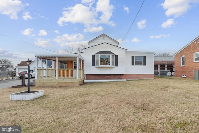 view of front facade with cooling unit, a porch, and a front lawn