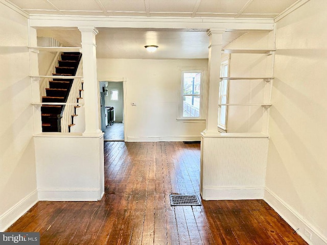 interior space featuring decorative columns and dark hardwood / wood-style floors