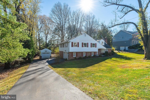 view of front of property with a front yard, an outbuilding, and a garage