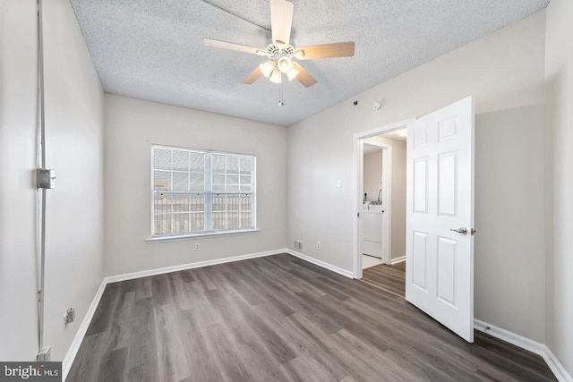 spare room featuring ceiling fan, dark hardwood / wood-style floors, and a textured ceiling