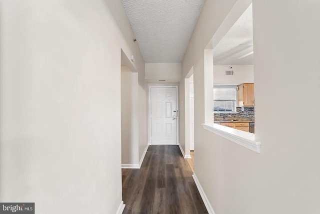 hallway with dark hardwood / wood-style floors and a textured ceiling