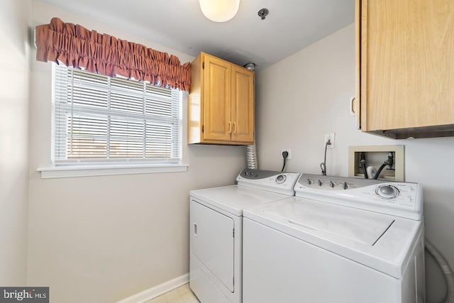 clothes washing area featuring cabinets and separate washer and dryer