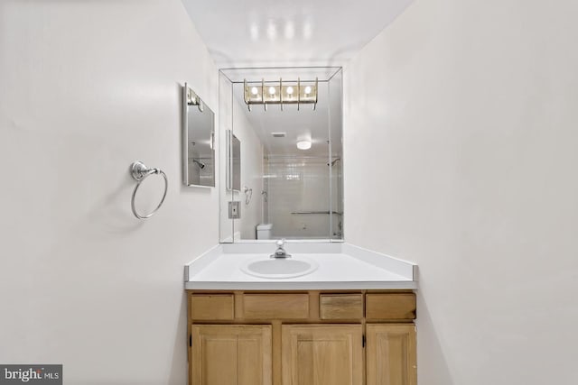 bathroom with an enclosed shower, vanity, and toilet