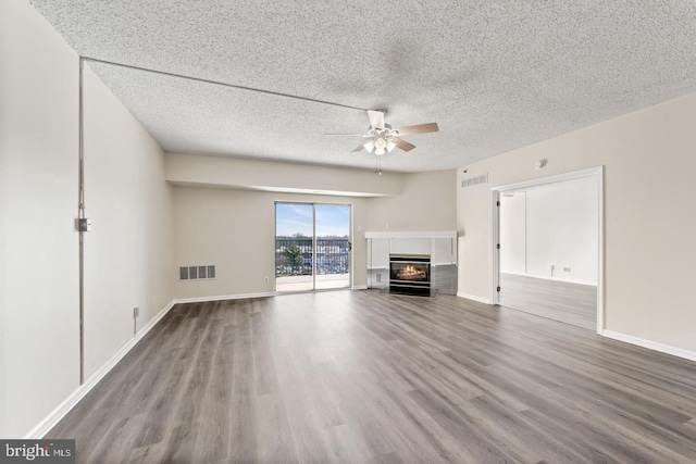 unfurnished living room featuring hardwood / wood-style floors, a textured ceiling, and ceiling fan