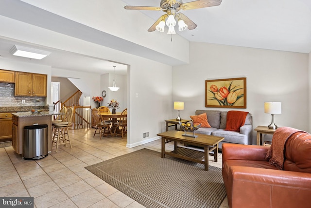 living room featuring ceiling fan, light tile patterned flooring, and lofted ceiling