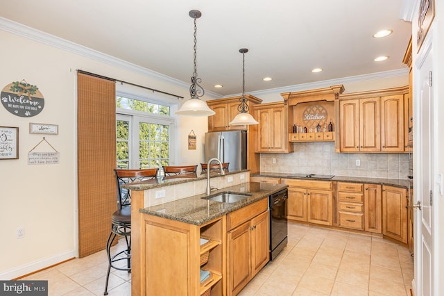 kitchen with a breakfast bar area, black appliances, an island with sink, pendant lighting, and sink