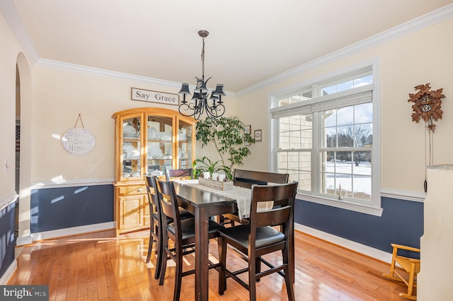 dining area with an inviting chandelier, hardwood / wood-style flooring, and crown molding