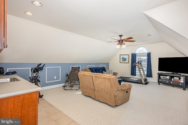 carpeted living room with lofted ceiling, sink, and ceiling fan