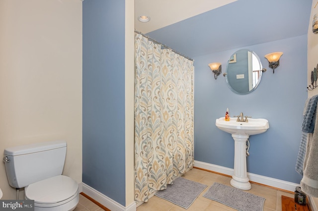 bathroom featuring toilet and tile patterned flooring